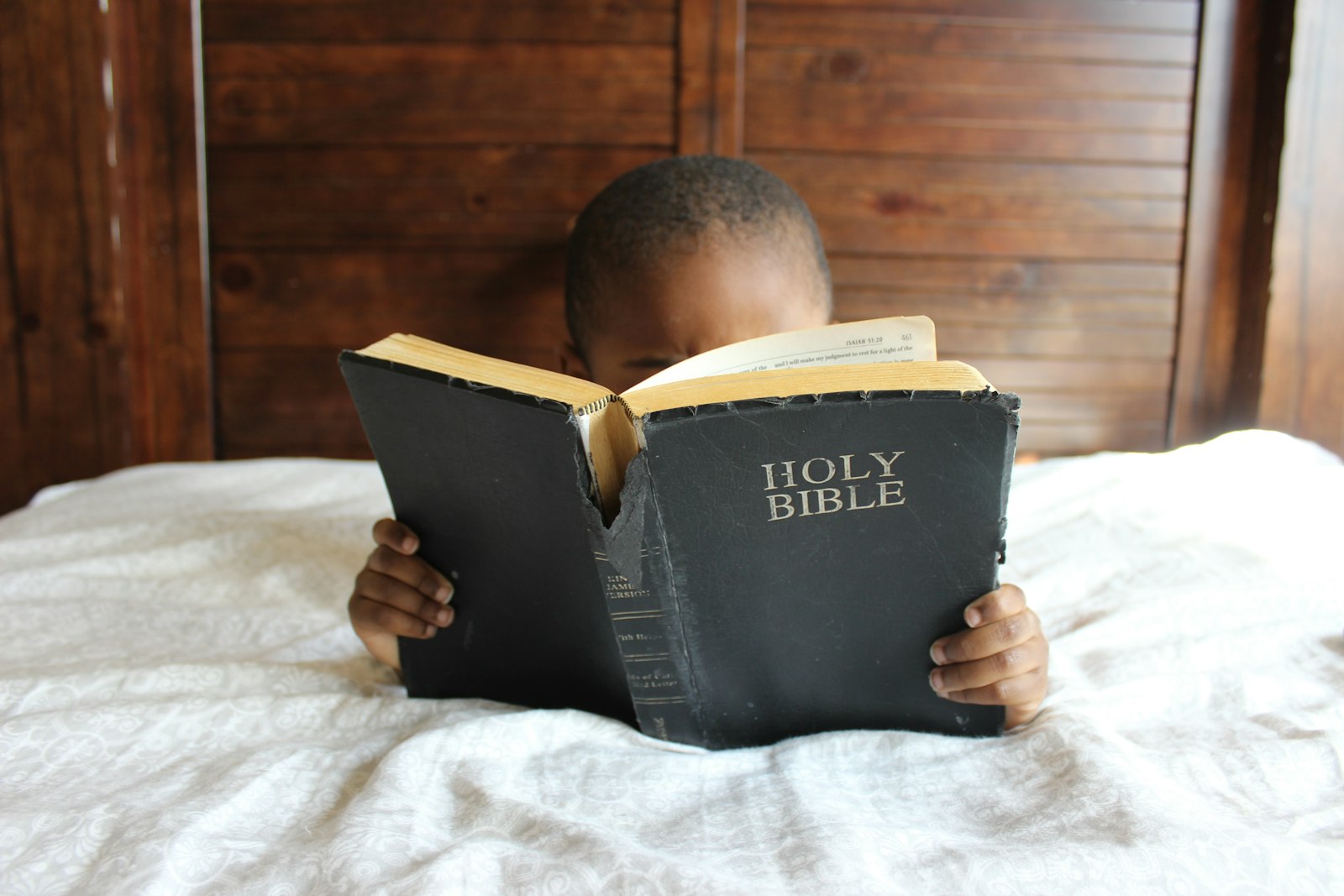 A young boy reading a Bible